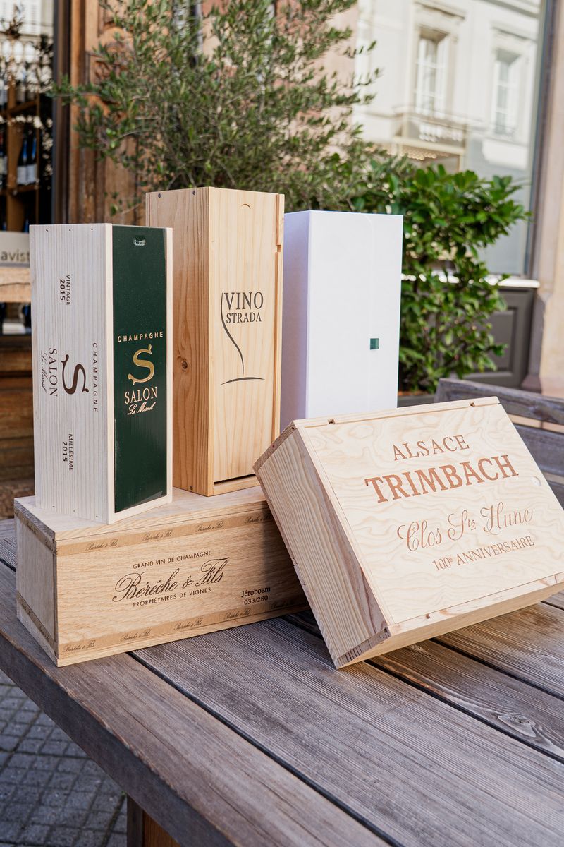 Caisses en bois de domaines et coffret VINO Strada sur une table en terrasse